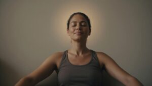 A person sitting comfortably with eyes closed, relaxed breathing